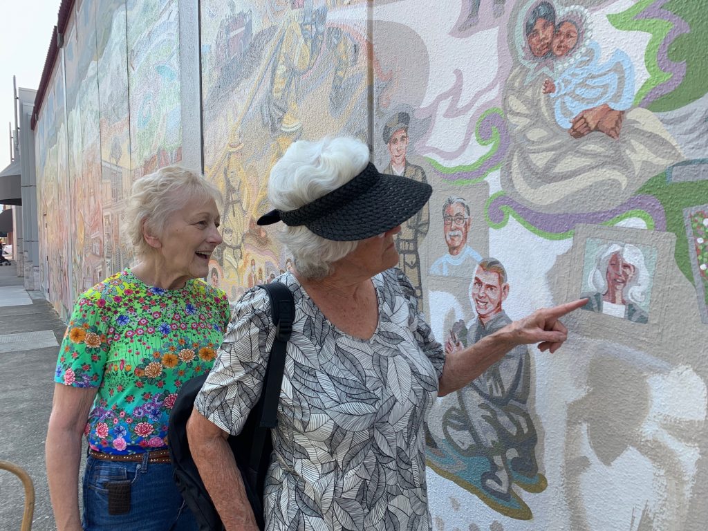 Two women recognize the portrait of Judy Pruden