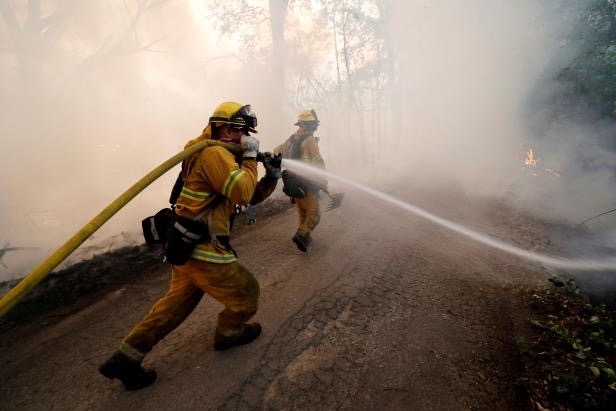 Firefighter aiming a hose downhill